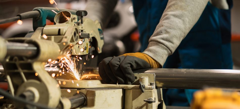Worker working with a circular grinder on a metal with sparks